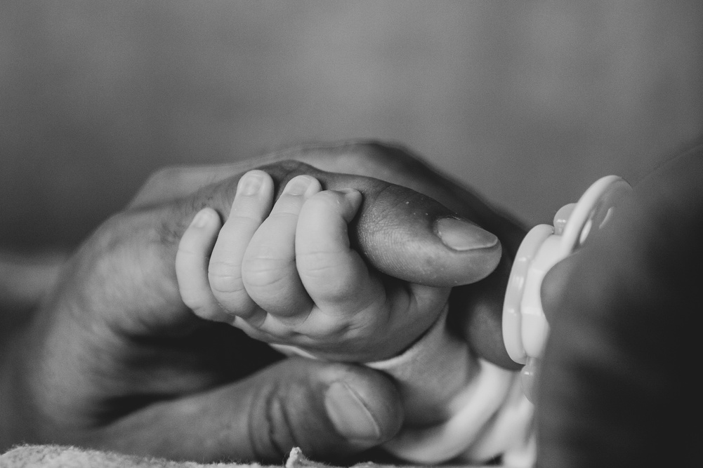 Grayscale Photo of a Baby Holding a Persons Finger